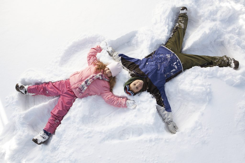 Children making snow angels --- Image by © Pauline St. Denis/Corbis