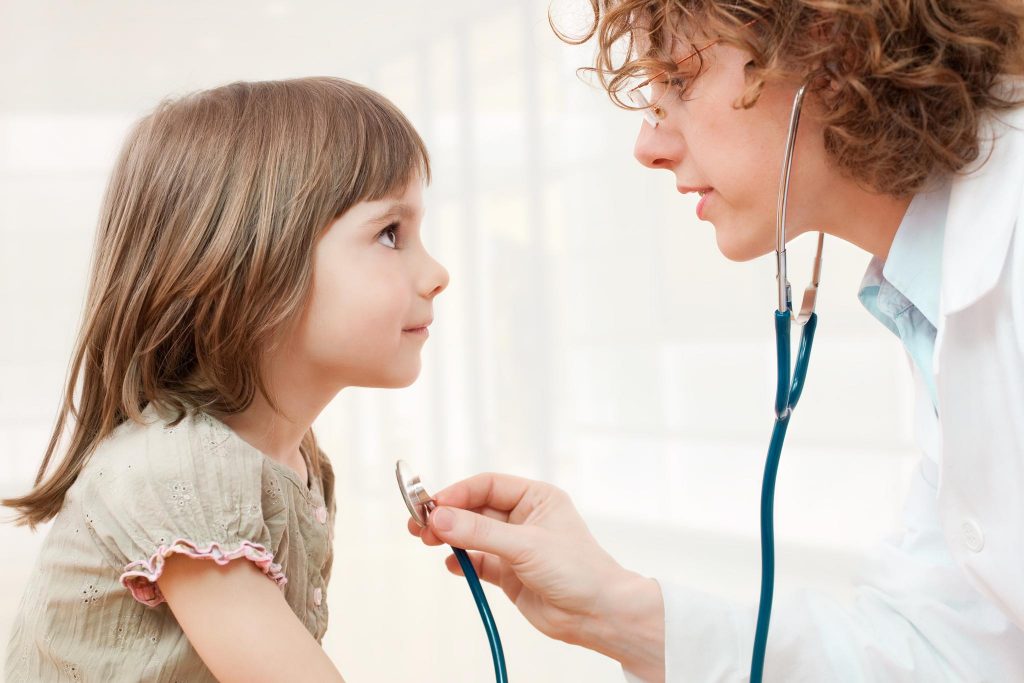 Female mature doctor examining little girl - closeup