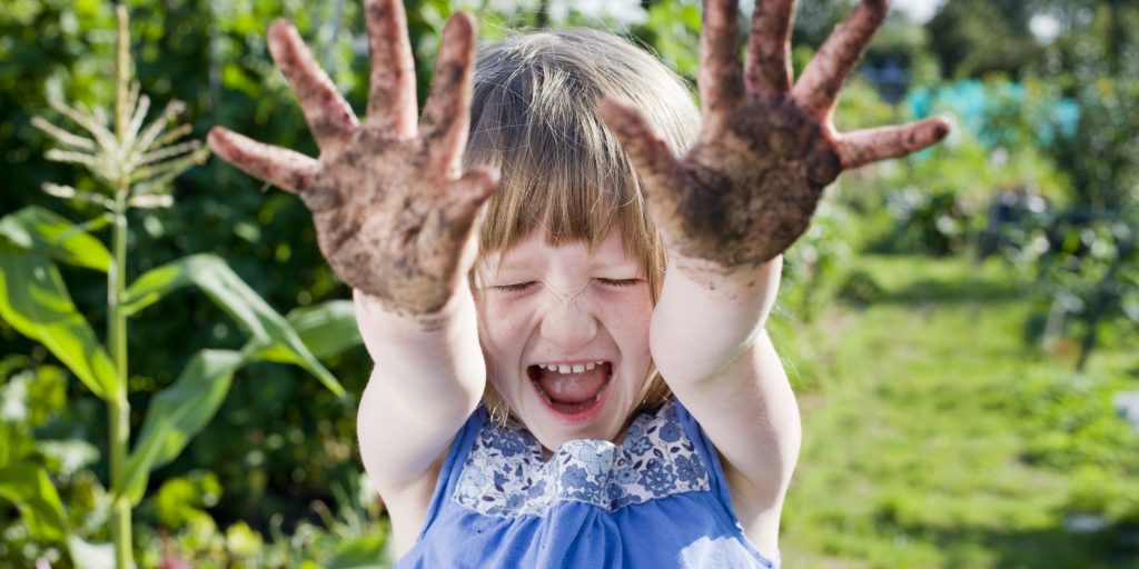 Girl(3-5) with mud hands